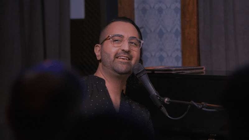 Ash singing at a microphone